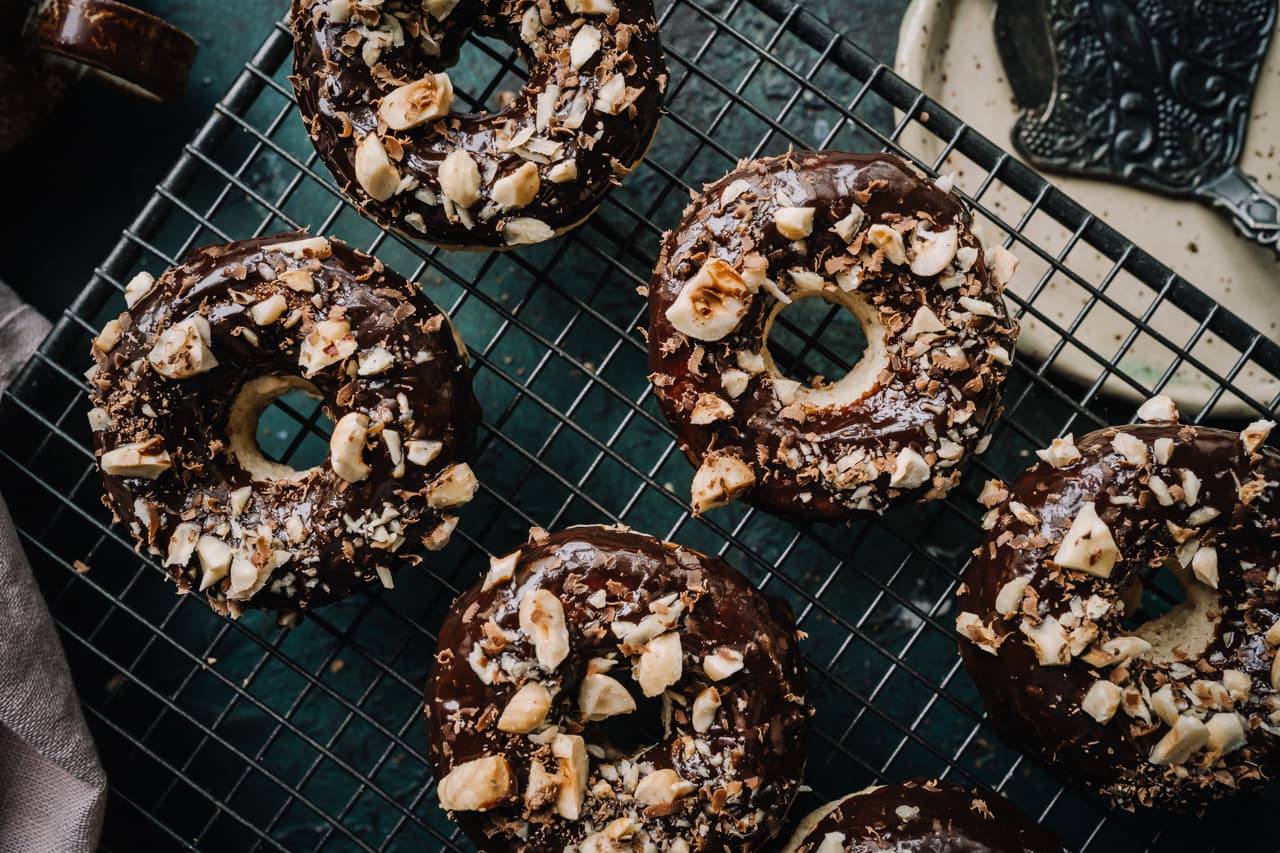 Annoskuva reseptistä Suklaalla kuorrutetut ja paahdetulla hasselpähkinärouheella koristellut vegaaniset donitsit kategorialle resepti