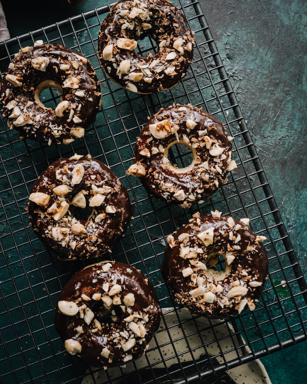 Annoskuva reseptille Suklaalla kuorrutetut ja paahdetulla hasselpähkinärouheella koristellut vegaaniset donitsit